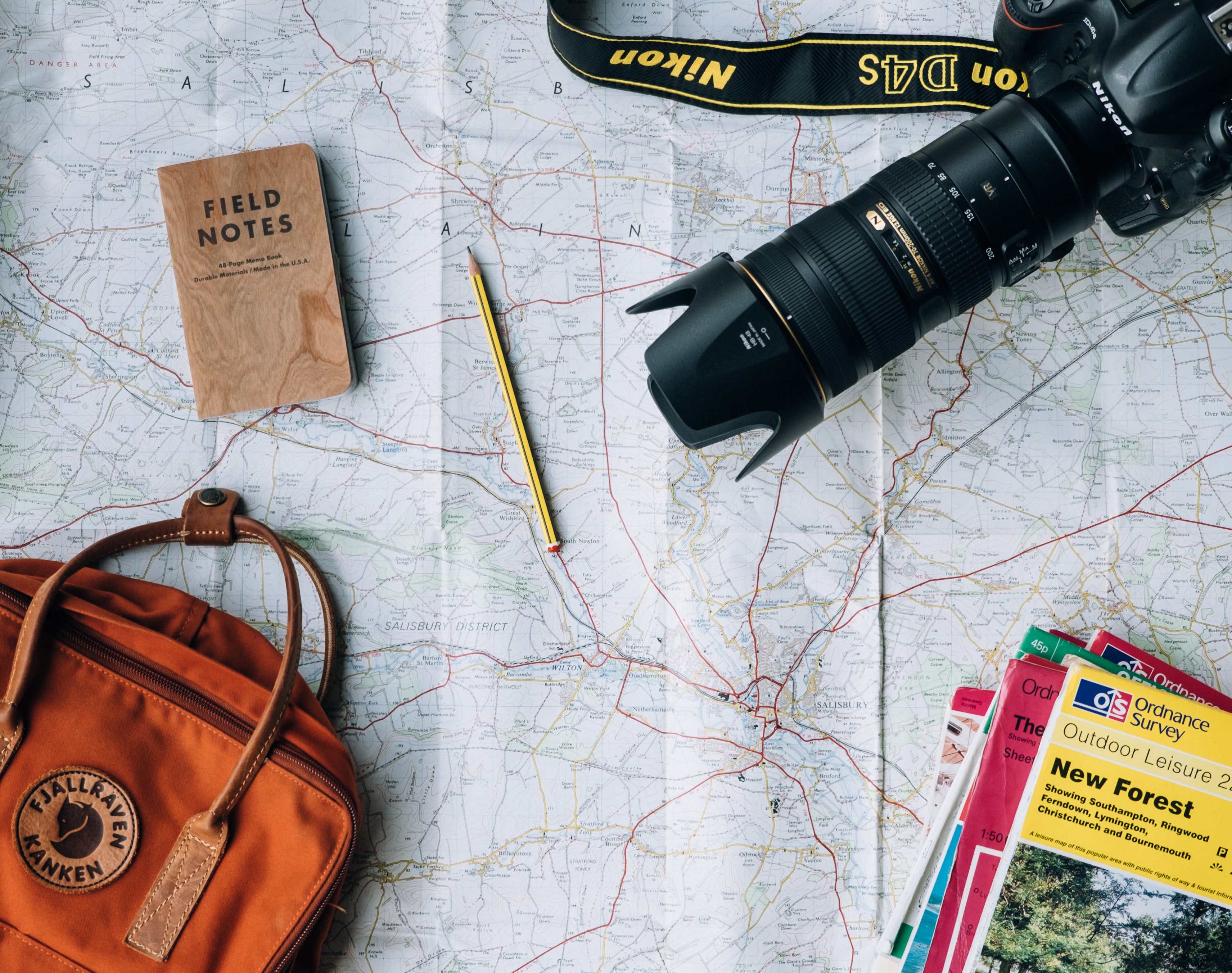 map with a camera, pensil, bag, and note book